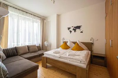a living room with a couch and a bed at Bright Ruterra Apartment in the Heart of Prague in Prague