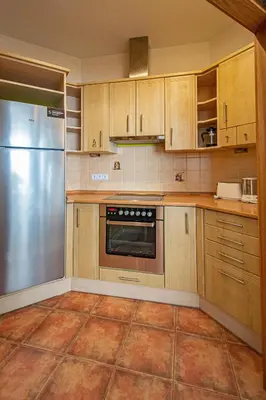 a kitchen with wooden cabinets and a stainless steel refrigerator at Bright Ruterra Apartment in the Heart of Prague in Prague