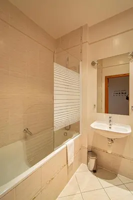 a bathroom with a bath tub and a sink at Bright Ruterra Apartment in the Heart of Prague in Prague