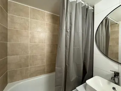 a bathroom with a shower curtain and a sink at 2BDR Pretty Apartment in the Local Area of Prague in Prague