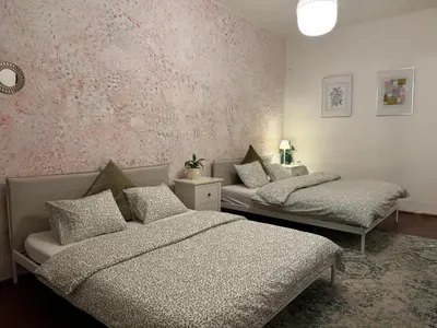 a bedroom with two beds and a pink wall at 2BDR Pretty Apartment in the Local Area of Prague in Prague