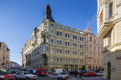 a large building with cars parked in front of it at Sleep & Go Single Room in Prague