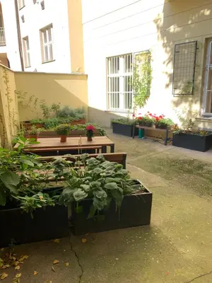 a garden with benches and plants in a courtyard at Sleep & Go Single Room in Prague