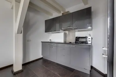a kitchen with stainless steel cabinets and a microwave at Spacious stylish attic in the heart of the center - Karlovo in Prague