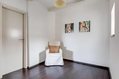 a white room with a chair and a painting at Spacious stylish attic in the heart of the center - Karlovo in Prague
