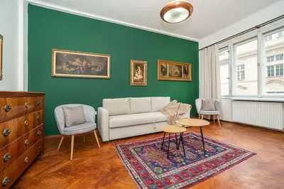 a living room with a couch and two chairs at Classic Old town stay in Prague