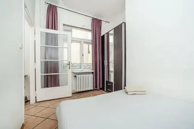 a bedroom with a white bed and a window at Classic Old town stay in Prague