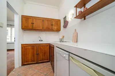 a kitchen with white counters and wooden cabinets at Classic Old town stay in Prague