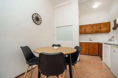 a kitchen with a table and chairs and a clock on the wall at Classic Old town stay in Prague