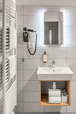 a white bathroom with a sink and a mirror at Theatre 9 Apartments by Adrez in Prague