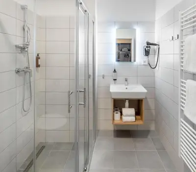 a bathroom with a glass shower and a sink at Theatre 9 Apartments by Adrez in Prague