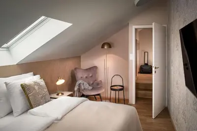 a bedroom with a bed and a chair at Theatre 9 Apartments by Adrez in Prague