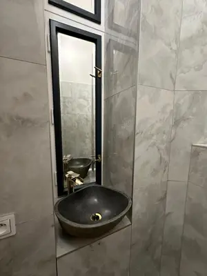 a bathroom with a black sink and a mirror at Cozy New Loft Apartment in Prague
