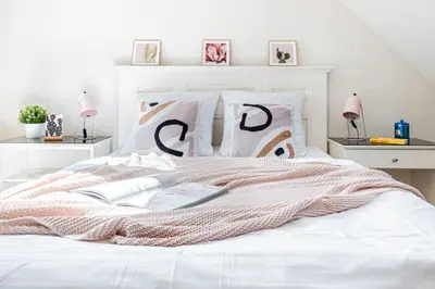 a white bed with a blanket and a book on it at Prague Days - Airy Duplex with Terrace and AC in Prague