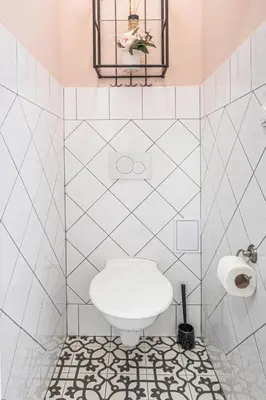 a white tiled bathroom with a toilet in it at Prague Days - Airy Duplex with Terrace and AC in Prague