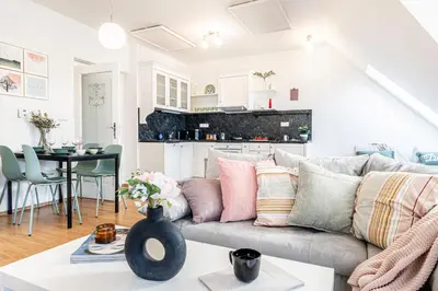 a living room with a couch and a kitchen at Prague Days - Airy Duplex with Terrace and AC in Prague