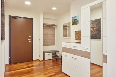 a kitchen with white cabinets and a wooden door at Spacious Condo in Nusle by Prague Days in Prague