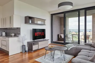 a living room with a couch and a tv and a kitchen at Spacious Condo in Nusle by Prague Days in Prague