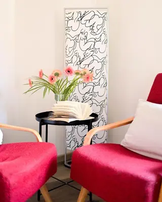 a room with two chairs and a table with a vase of flowers at Modern apartment Krymská & Francouzská street in Prague
