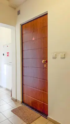 a wooden door in a room with a tile floor at Modern apartment Krymská & Francouzská street in Prague