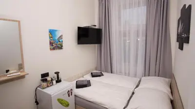 a small bed in a room with a window at Apartment CONTINENTS nearby Main Train and Bus Station in Prague