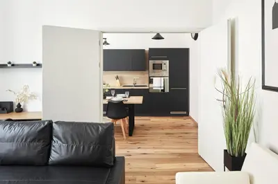 a living room with a couch and a kitchen at Prague Days - One-bedroom Apartment with Workspace by Vltava River in Smíchov in Prague