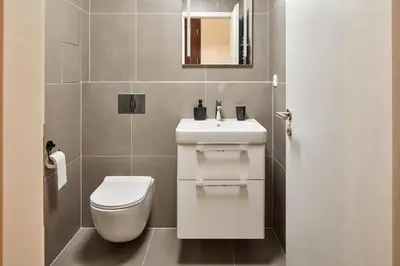 a bathroom with a white toilet and a sink at Prague Days - One-bedroom Apartment with Workspace by Vltava River in Smíchov in Prague