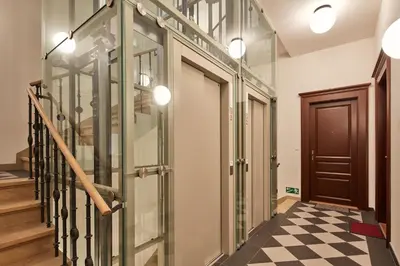 a hallway with glass doors and a checkered floor at Prague Days - One-bedroom Apartment with Workspace by Vltava River in Smíchov in Prague