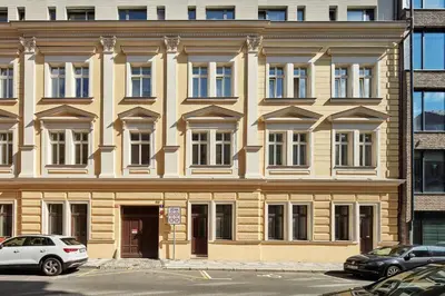 a large building with cars parked in front of it at Prague Days - One-bedroom Apartment with Workspace by Vltava River in Smíchov in Prague