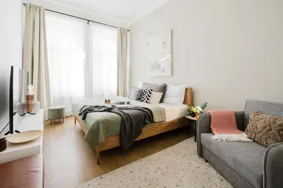 a bedroom with a bed and a couch at Prague Days - Sunlit 1BDR Apartments w Netflix in New Town in Prague