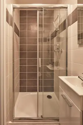 a shower with a glass door next to a sink at Prague Days - Sunlit 1BDR Apartments w Netflix in New Town in Prague