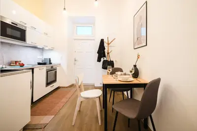 a kitchen with a table and chairs in a kitchen at Prague Days - Sunlit 1BDR Apartments w Netflix in New Town in Prague