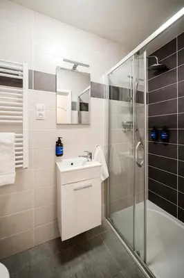 a white bathroom with a sink and a shower at Prague Days - Sunlit 1BDR Apartments w Netflix in New Town in Prague
