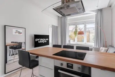 a white bedroom with a bed and a book shelf at Prague Days - One-bedroom Apartment with Courtyard View in Karlín in Prague