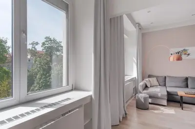 a kitchen with a wooden table and black chairs at Prague Days - One-bedroom Apartment with Courtyard View in Karlín in Prague