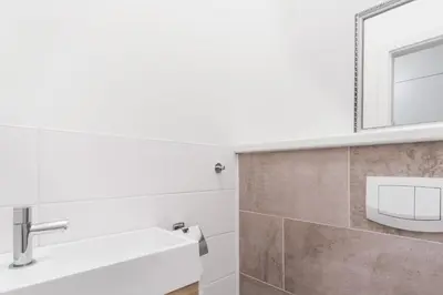 a hallway leading into a kitchen with white walls and a mirror at Prague Days - One-bedroom Apartment with Courtyard View in Karlín in Prague