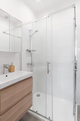 a kitchen with white cabinets and a table and a chair at Prague Days - One-bedroom Apartment with Courtyard View in Karlín in Prague