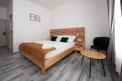a bedroom with a bed and a desk and a chair at Penzion MOVEINN in Prague
