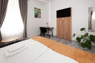 a hotel room with a bed and a flat screen tv at Penzion MOVEINN in Prague