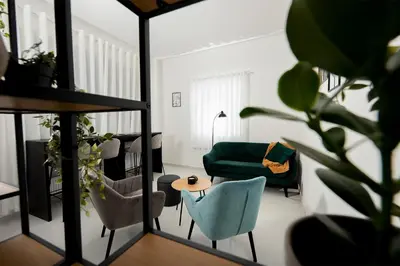 a living room with a green couch and chairs at Penzion MOVEINN in Prague