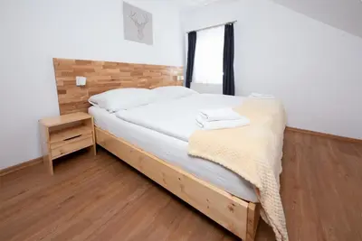 a bedroom with a bed and a wooden floor at Penzion MOVEINN in Prague