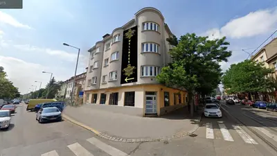a building on a street with cars parked in front of it at Afrodita Wellness Apartman Prague in Prague