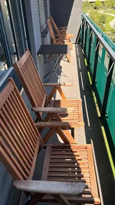 three wooden chairs sitting on the side of a building at Apartman Holesovice,balkon,garaz in Prague
