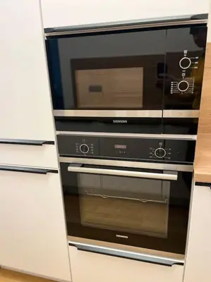 a microwave oven sitting inside of a white cabinet at Apartman Holesovice,balkon,garaz in Prague