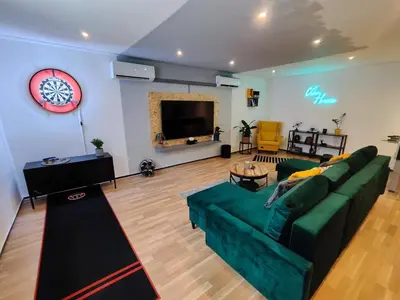 a living room with a green couch and a flat screen tv at Vibe House Prague in Prague