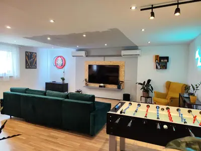 a living room with a couch and a pool table at Vibe House Prague in Prague