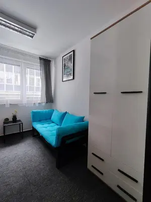 a living room with a blue couch and a cabinet at Vibe House Prague in Prague