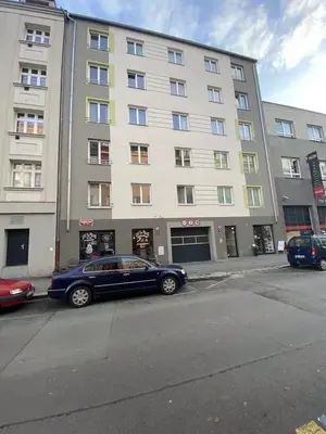 a blue car parked in front of a large building at Apartments / 10 min from center / O2 ARENA in Prague