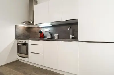a kitchen with white cabinets and a sink at Apartments / 10 min from center / O2 ARENA in Prague