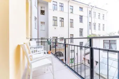 a balcony with two chairs and a white building at Favorite apartment in the center of Prague 1 in Prague